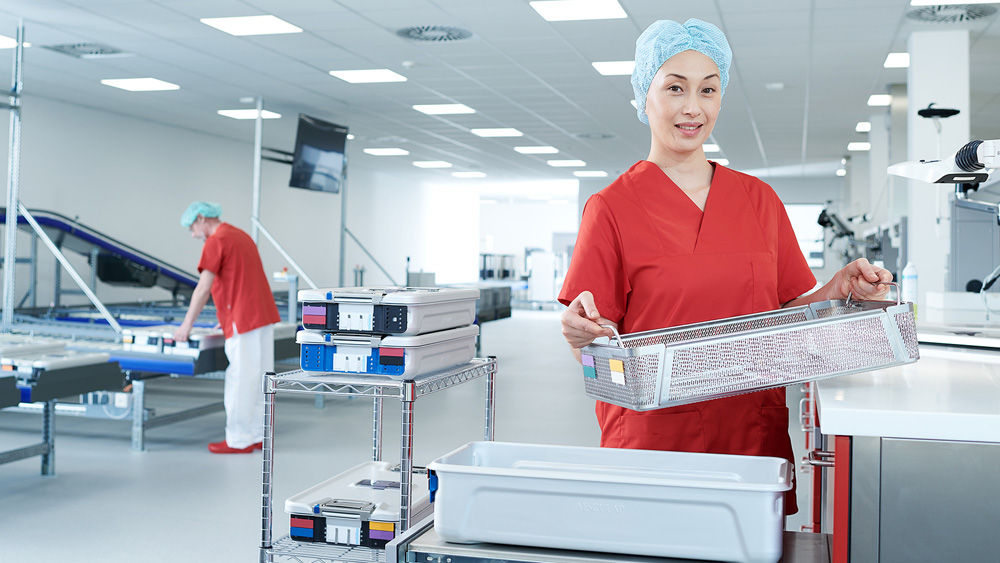 Two workers holding metal containers in a factory setting