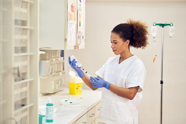 Nurse in examination room preparing drugs