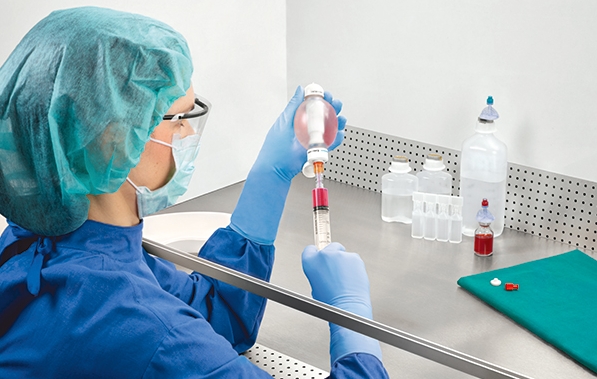 Nurse with syringe and container for drug compounding