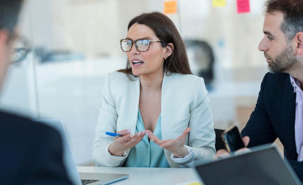 A professional and a doctor discussing medical information on a tablet in a meeting room. 
